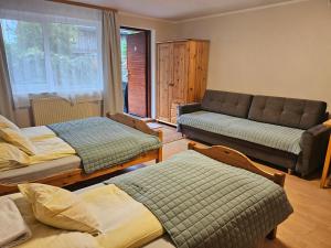 ein Wohnzimmer mit drei Betten und einer Couch in der Unterkunft Aga Mielenko Pokoje i Apartamenty in Mielenko