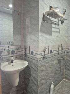 a bathroom with a sink and a mirror at Hyper house hotel in Buôn Ðũng