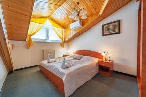 a bedroom with a large bed with a wooden ceiling at Hotel Ferum in Šaca