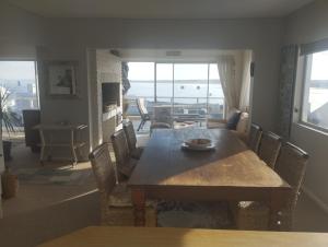 a dining room table and chairs with a view of the ocean at Sea Echo in Yzerfontein