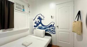 a small room with a blue and white painting on the wall at Dormitelsph BGC in Manila +152 photos