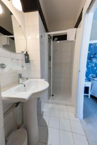 a white bathroom with a sink and a shower at Hôtel Le Cobh in Ploërmel +21 photos
