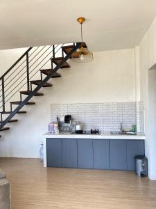 a kitchen with a sink and a staircase at Oemah Ntuy Full view in Diyeng