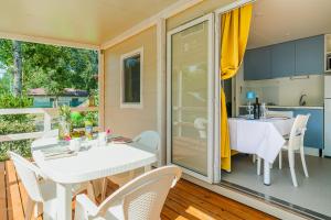 a dining room with a table and chairs on a balcony at Massa Marina Camping in Marina di Massa
