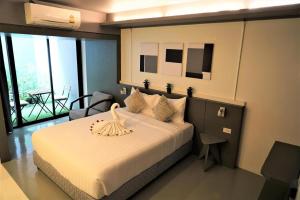 a bedroom with a large bed and a balcony at Silom Studios in Bangkok