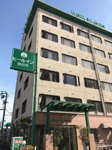 un edificio con un letrero de la calle delante de él en Heal In Yokkaichi, en Yokkaichi