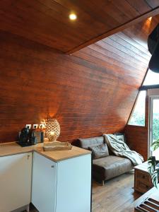 a living room with wooden walls and a couch at le moodeng in Villampuy
