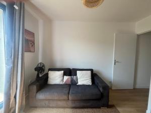 a couch sitting in a living room next to a window at Le cocon Panoramique in Tours