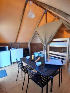 a table and chairs in a room with a kitchen at Camping Port la Vallée in Saint-Mathurin