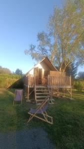 a cabin with two chairs and a tent at Camping Port la Vallée in Saint-Mathurin