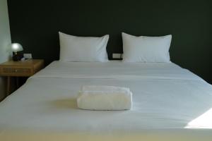 a white bed with a bowl on top of it at โรงแรมเดย์โฮเต็ล in Khon Kaen
