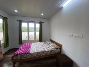 a small bedroom with a bed and a window at SOLITUDE Riverside Holiday Home in Vallikunnu