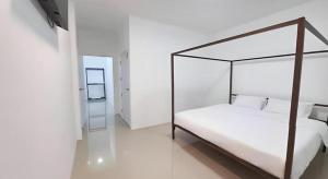 a bedroom with a canopy bed in a white room at WICKET WHITE VILLA in Ban Bang Lao (3)