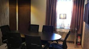 a dining room with a table and chairs and a window at Maxx Hotel Ortigas in Manila
