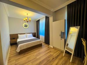 a bedroom with a bed and a mirror on the wall at Fethibey Otel in Bartın