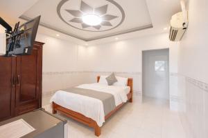 a bedroom with a bed and a flat screen tv at TRUNG LÀI HOTEll in Ấp Thái Thương +2 photos