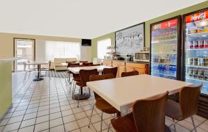 a restaurant with tables and chairs and a refrigerator at Super 8 by Wyndham Denver Central in Denver