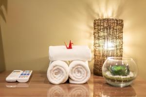 a table with towels and a remote control and a bowl at Hotel 向日葵 in Osaka +81 photos