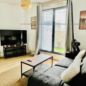 a living room with a couch and a table at Le cocon Panoramique in Tours