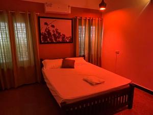 a red bedroom with a large bed in it at Coliveinn in Ernakulam