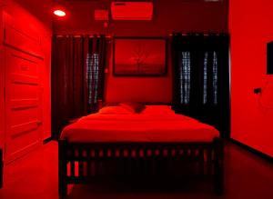 a red bedroom with a bed with a red ceiling at Coliveinn in Ernakulam +2 photos