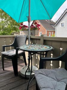 a table and chairs on a balcony with an umbrella at Macke`s 4 & 5 Sterne Ferienwohnungen in Hahnenklee-Bockswiese