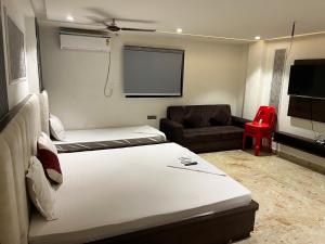 a room with two beds and a flat screen tv at Bodhi international in Gaya