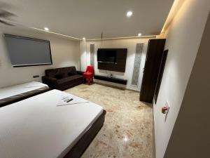 a room with a bed and a couch and a flat screen tv at Bodhi international in Gaya