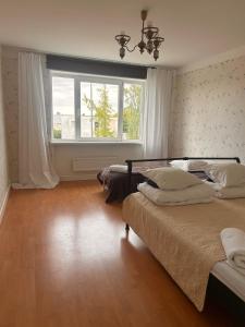 a bedroom with two beds and a window at Ottenson Saaremaa apartment in Salme