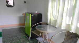 a small table and a small green refrigerator in a room at Na Chan Resort in Ban Khlong Khlung (1)