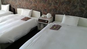 dos camas sentadas una al lado de la otra en una habitación en Heal In Yokkaichi, en Yokkaichi