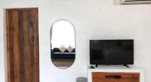 a living room with a tv and a mirror at Samunthitar Resort in Khao Kho
