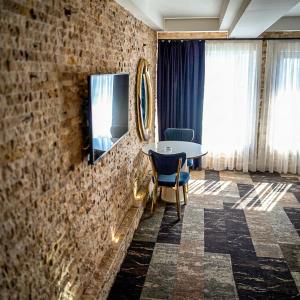 a room with a table and a tv on a brick wall at Panorama Rezidans Kayseri in Kayseri