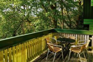 a patio with a table and chairs on a fence at Tor View Lodge with Hot Tub & Sauna - Spa Resort - South Devon in Chudleigh