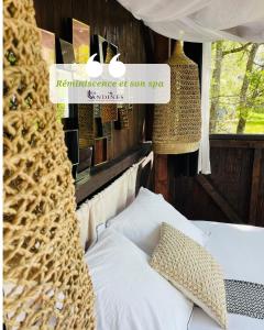 a bedroom with a bed and a sign that reads resonance of son spa at Cabanes et Spa Les Landines in Origne