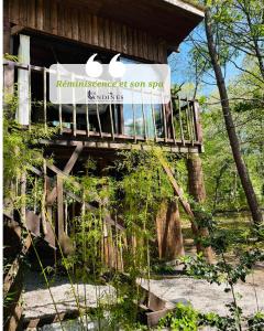 a sign on the side of a tree house at Cabanes et Spa Les Landines in Origne