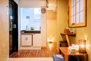 a kitchen and a living room with a table at Hotel 向日葵 in Osaka