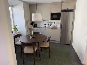 a kitchen with a table and chairs and a refrigerator at Apartments Strandgatan Visby in Visby
