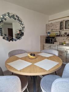 a dining room table with chairs and a mirror at Miljana in Vukovar