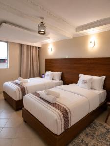 a hotel room with two beds in a room at Novo Axora Lounge & Accommodation Kimbo Ruiru Kimbo Lopha Stage in Ruiru