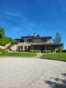 a large stone house on a hill with a driveway at Agriturismo Fontesomma in Apecchio