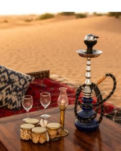 a table with wine glasses and a tea pot on the beach at Jaisalmer Desert Camp in Sām