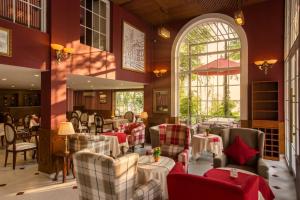 a restaurant with red and white furniture and a large window at Hotel L Odeon Phu My Hung in Ho Chi Minh City
