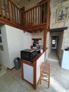 a kitchen with a stove and a wooden staircase at Le pressoir du prieuré in Ligré
