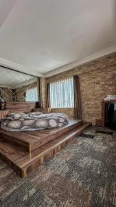 a bedroom with a large bed and a brick wall at Panorama Rezidans Kayseri in Kayseri