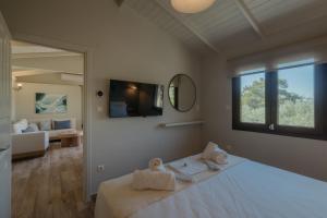 a bedroom with a bed and a living room at Millstone Summerhouse in Pachis