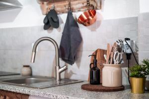 a kitchen counter with a sink and utensils at Refúgio da Mel - Piscinas e Praia fluvial próximas in Alandroal +42 photos