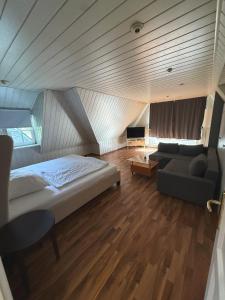 a bedroom with a bed and a couch and a table at Hotel Haus Hubertus in Schneverdingen