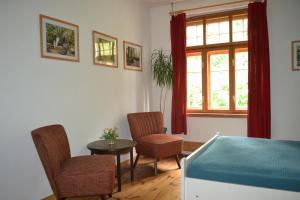 a bedroom with a bed and a table and chairs at Herberge Vitopia in Magdeburg +1 photo