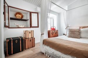 a white bedroom with a bed and a mirror at Refúgio da Mel - Piscinas e Praia fluvial próximas in Alandroal